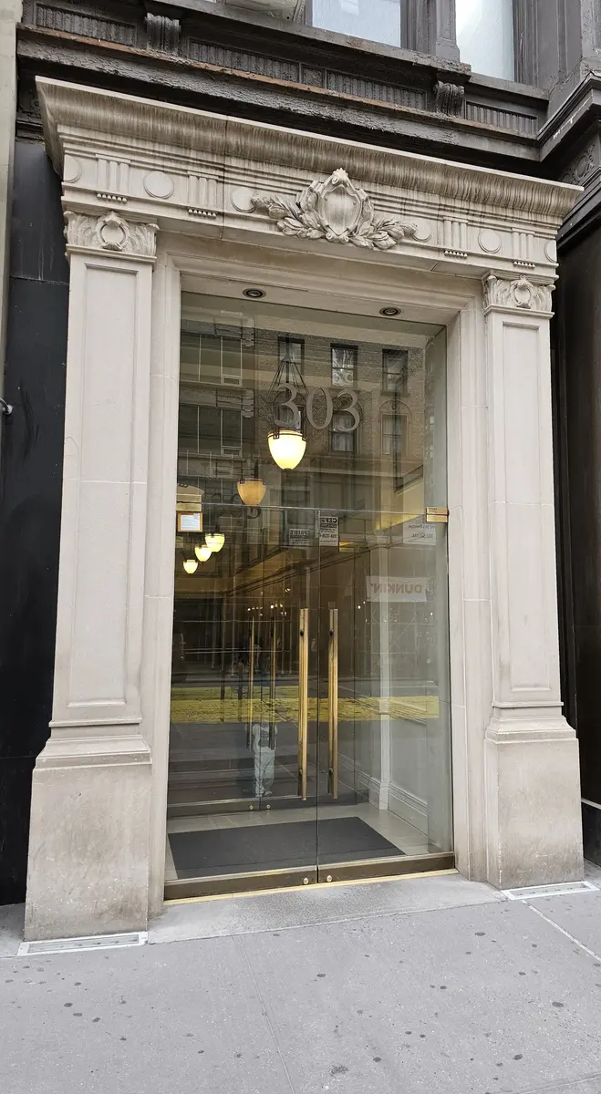 The detailed stone entrance to 303 Fifth Avenue